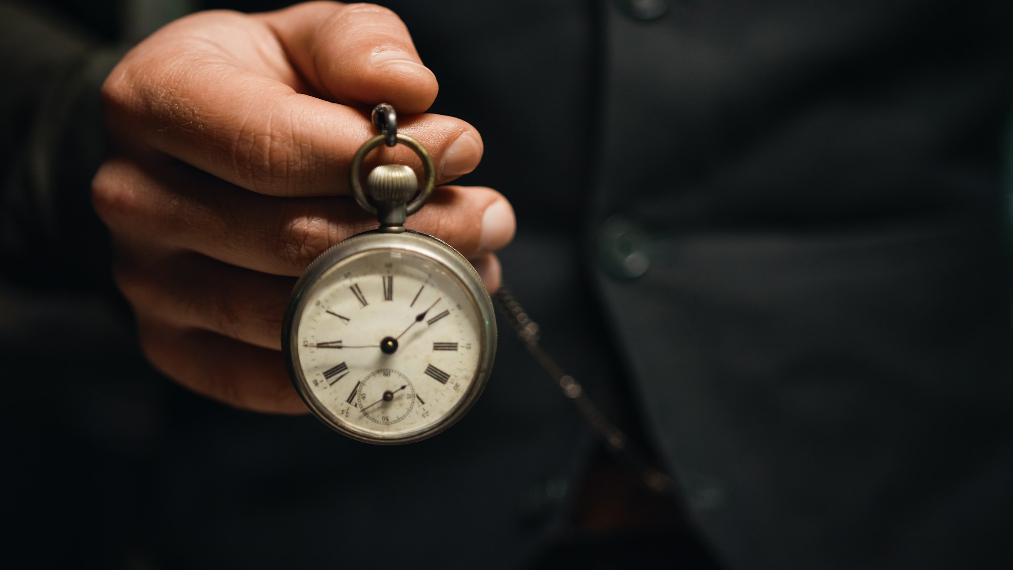 Man holds pocket watch in hand