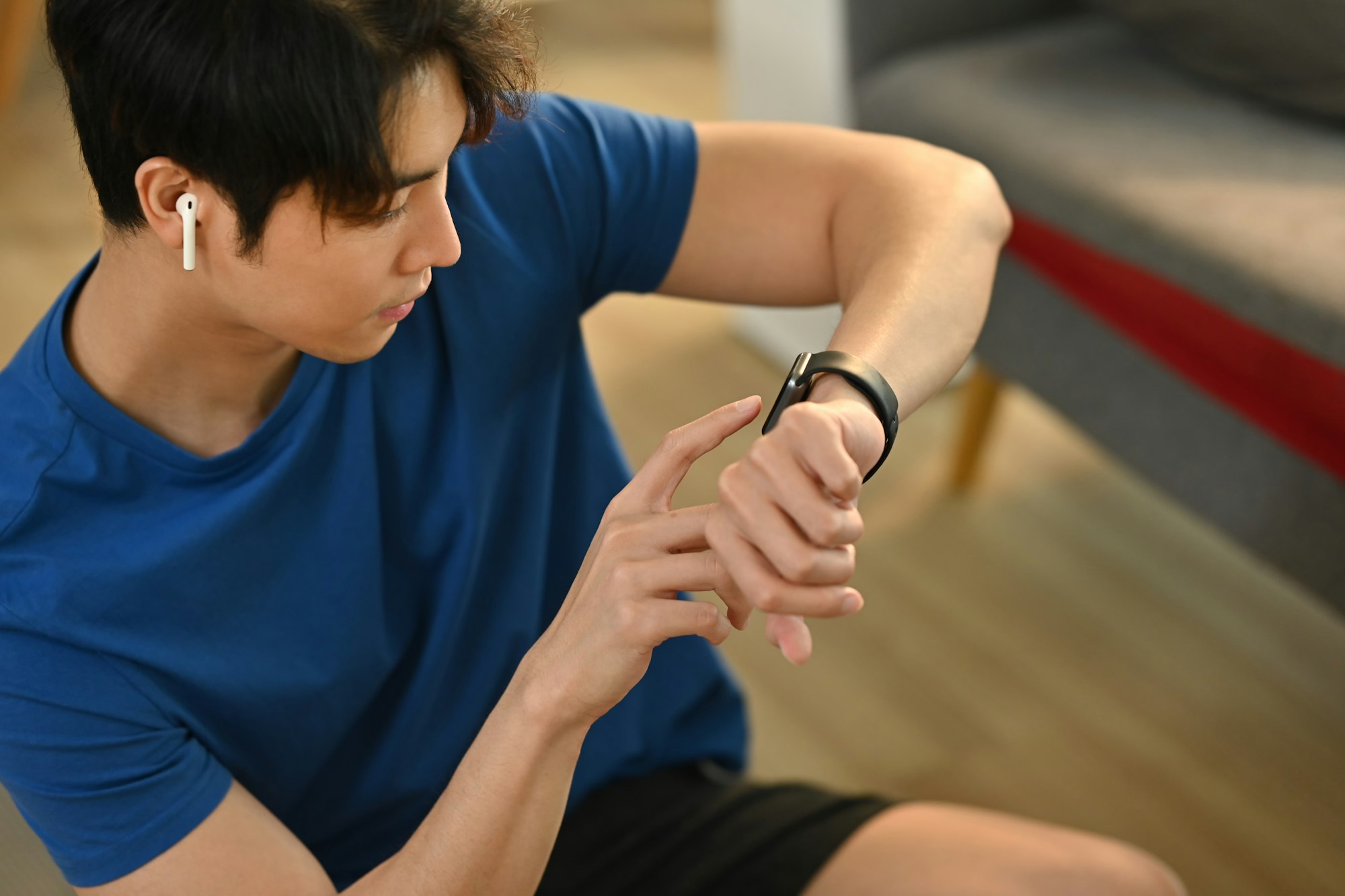 Young fitness man checking smartwatch to monitor training results.